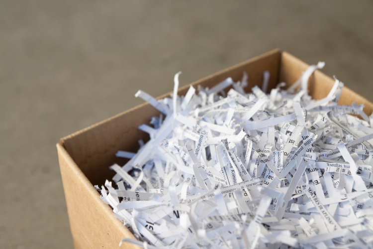 Shredded paper filling a cardboard box for secure document disposal